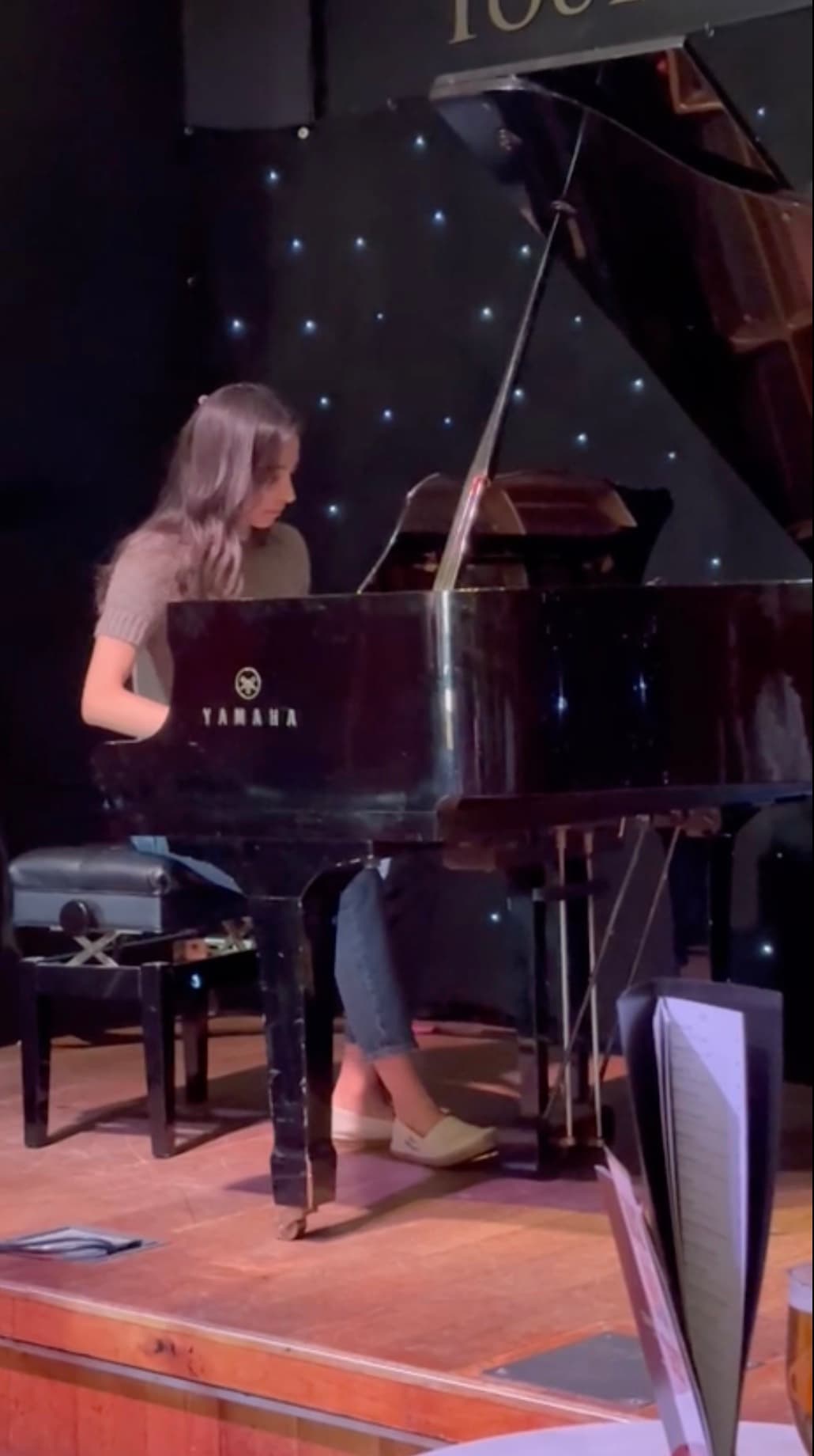 A student at the keys of the Yamaha grand piano